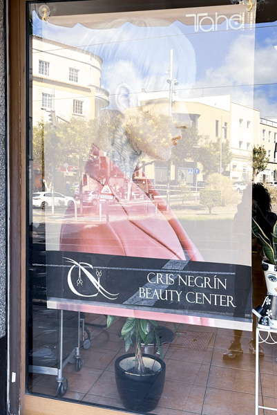 parte exterior del salón de belleza con cartel con una mujer de pelo corto