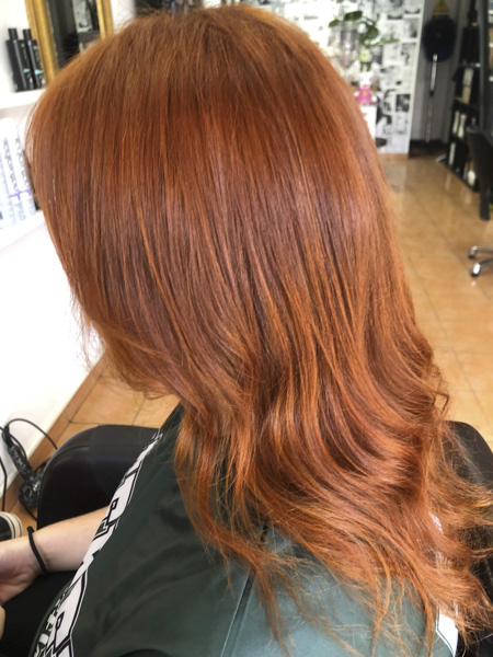 pelo teñido de rojo y ligeramente ondulado por abajo